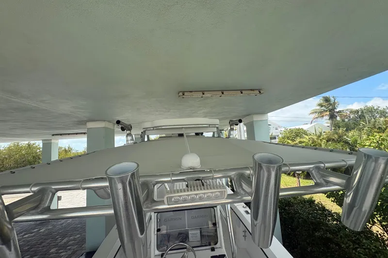 Slide: The Image of 2025 Whitewater 28 boat under a covered dock with lush greenery in the background. - 17