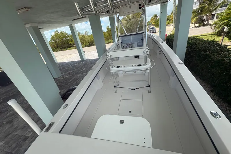 Slide: The Image of 2025 Whitewater 28 boat interior under a covered dock, showcasing helm and seating area. - 8