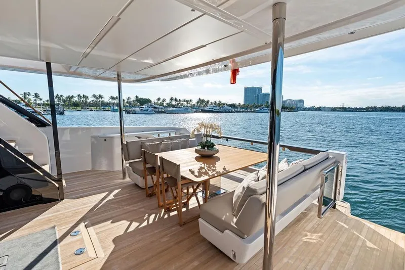 Slide: The Image of Luxurious 2023 Ferretti Yachts 860 deck with elegant seating and scenic waterfront view. - 35