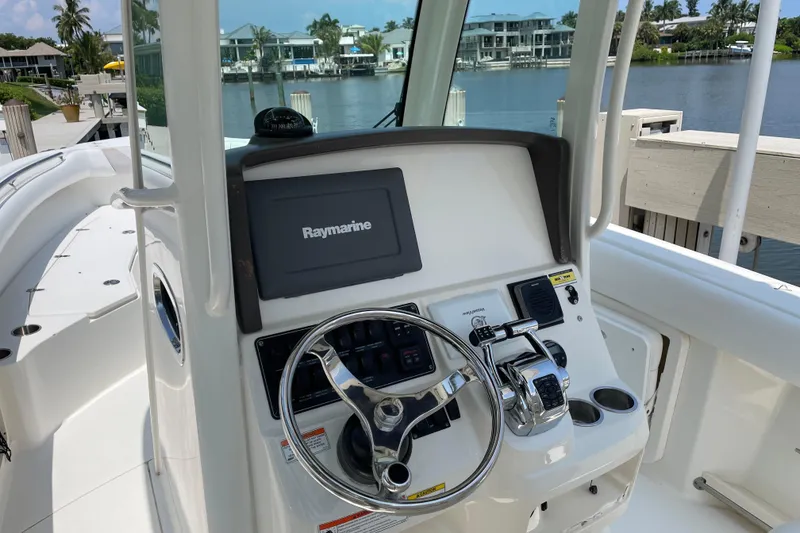 Slide: The Image of 2009 Boston Whaler 280 Outrage helm with Raymarine electronics, docked by waterfront homes. - 14