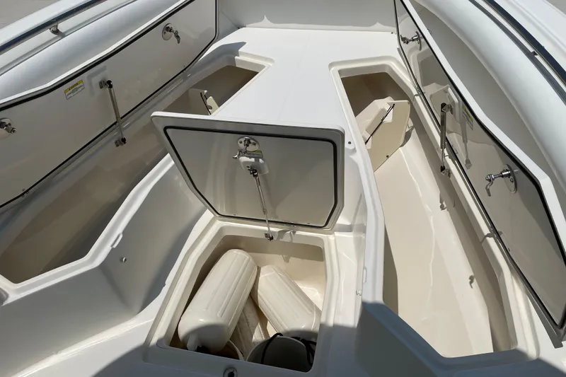 Slide: The Image of 2009 Boston Whaler 280 Outrage boat storage compartments with open hatches and fenders. - 16