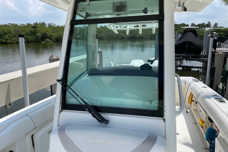 Slide: The Image of 2009 Boston Whaler 280 Outrage boat docked by a serene waterfront. - 21