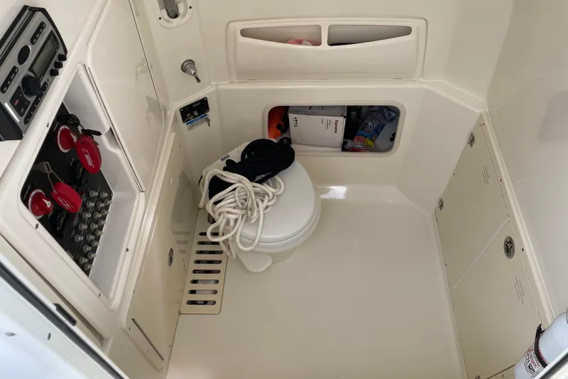 Slide: The Image of Interior of a 2009 Boston Whaler 280 Outrage boat, featuring a compact marine toilet. - 23