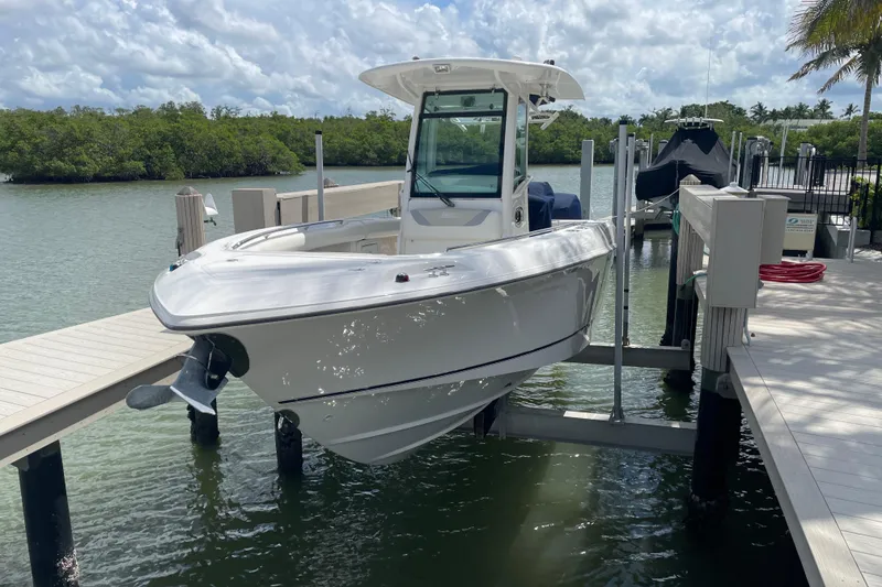 Slide: The Image of 2009 Boston Whaler 280 Outrage boat docked on a lift by the water. - 28