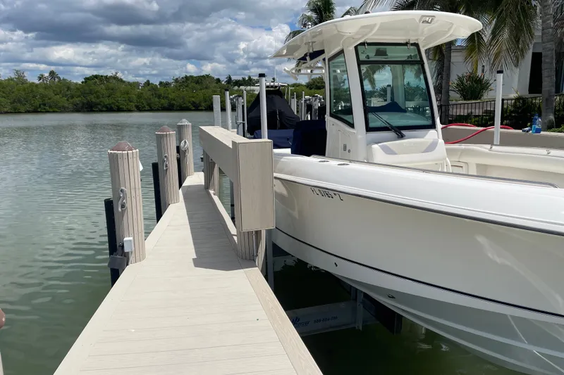 Slide: The Image of 2009 Boston Whaler 280 Outrage docked by a scenic waterfront under cloudy skies. - 32