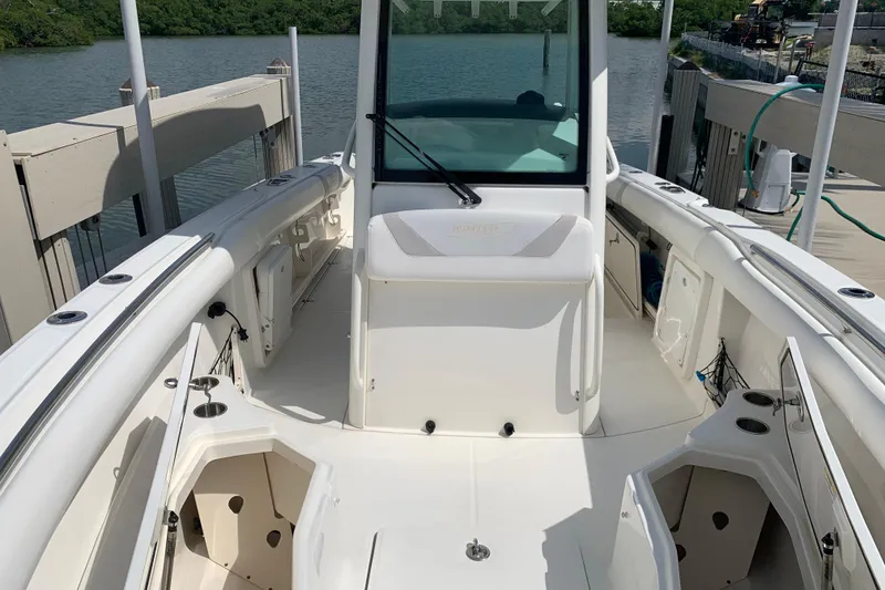 Slide: The Image of 2009 Boston Whaler 280 Outrage boat interior, docked by a serene waterfront. - 8