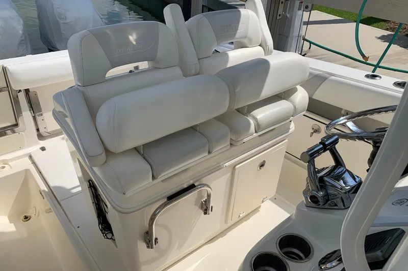 Slide: The Image of 2009 Boston Whaler 280 Outrage boat interior with white seating and steering wheel. - 9