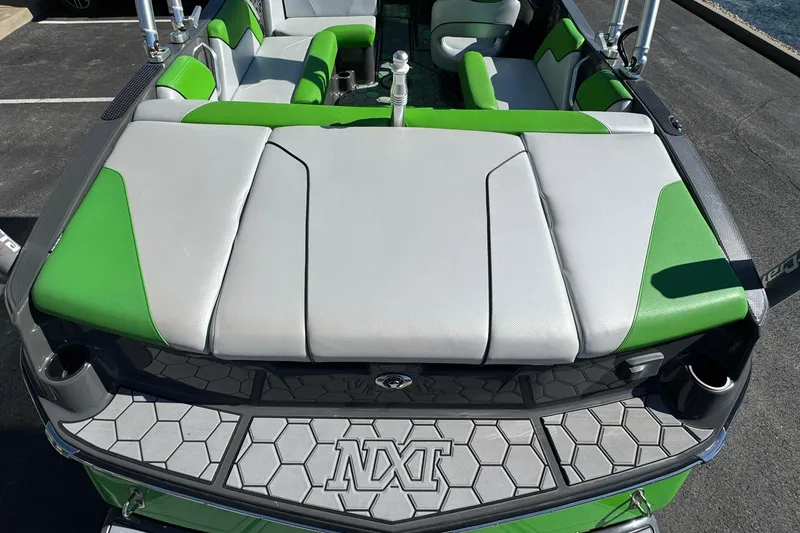 Slide: The Image of 2015 MasterCraft NXT20 boat interior with green and gray seating, hexagonal deck pattern. - 10