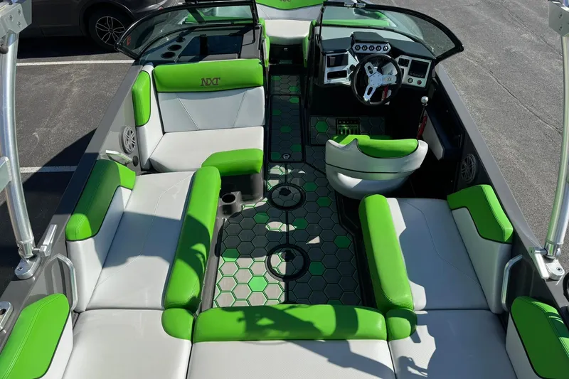 Slide: The Image of 2015 MasterCraft NXT20 boat interior with green and gray seating and hexagonal floor design. - 14