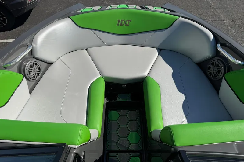 Slide: The Image of 2015 MasterCraft NXT20 boat interior with green and gray seating, featuring speakers. - 17