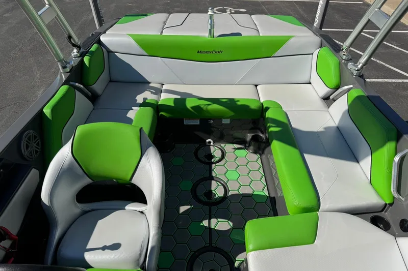 Slide: The Image of 2015 MasterCraft NXT20 boat interior with green and gray seating, hexagonal floor design. - 19