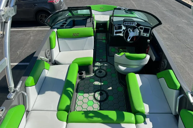 Slide: The Image of 2015 MasterCraft NXT20 boat interior with green and gray seating, hexagonal floor design. - 21
