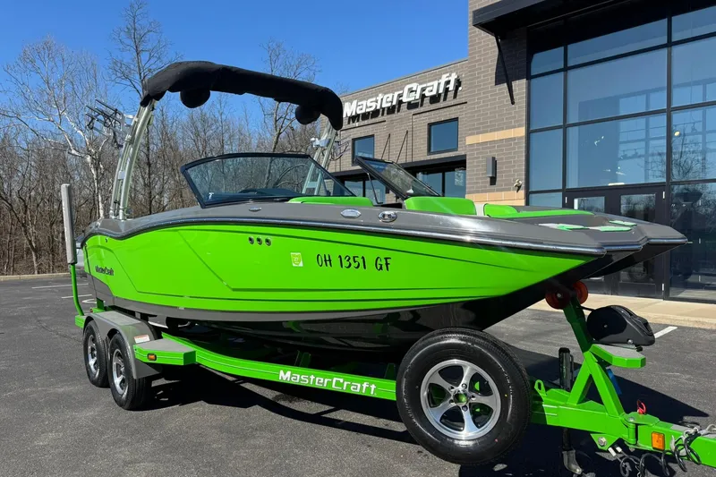 Slide: The Image of 2015 MasterCraft NXT20 boat in vibrant green, parked outside dealership. - 3