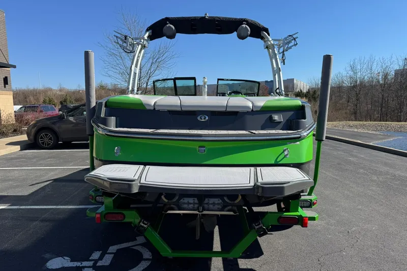 Slide: The Image of 2015 MasterCraft NXT20 boat, green exterior, parked outdoors on a sunny day. - 5