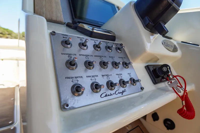 Slide: The Image of Control panel of a 2017 Chris-Craft Calypso 26 boat with labeled switches. - 12