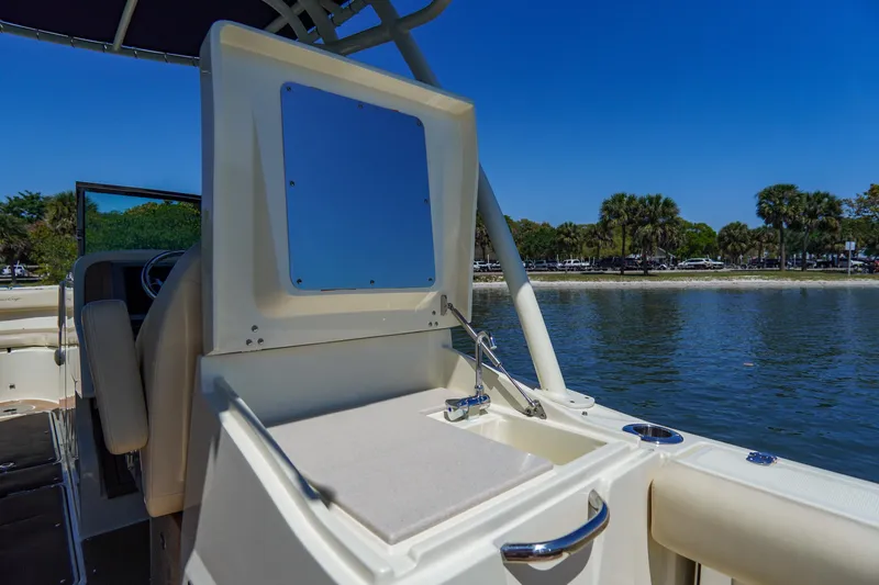 Slide: The Image of 2017 Chris-Craft Calypso 26 boat interior with sink, near scenic shoreline. - 17