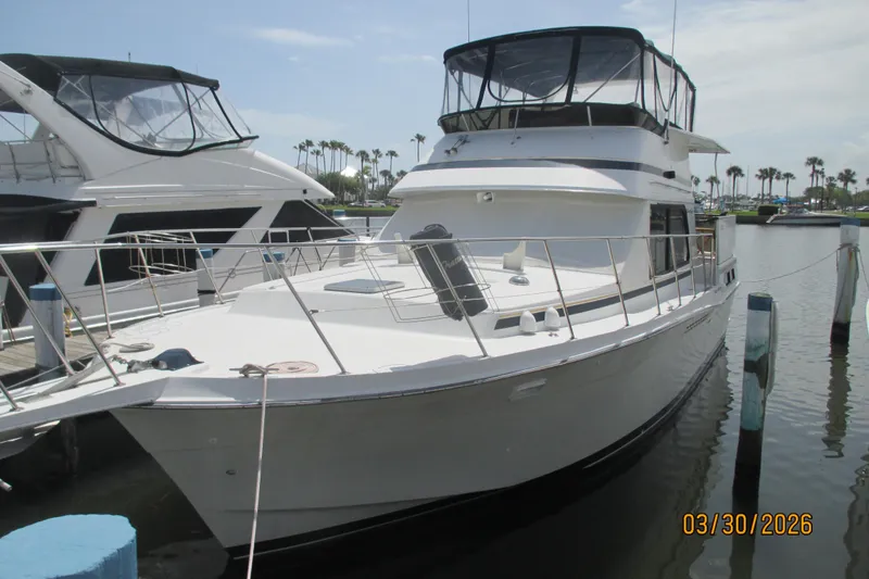 Slide: The Image of 1989 Chris Craft 427 yacht docked at marina, featuring sleek design and spacious deck. - 1