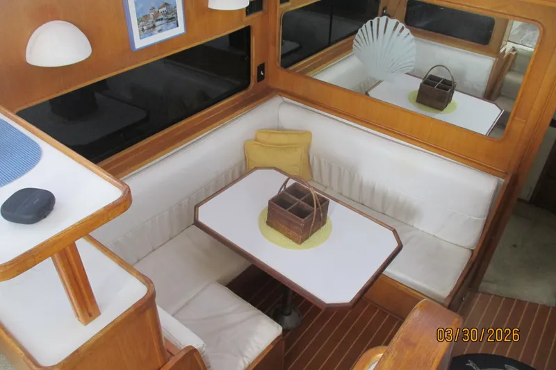 Slide: The Image of Interior of 1989 Chris Craft 427 yacht with cozy dining area and wooden accents. - 12