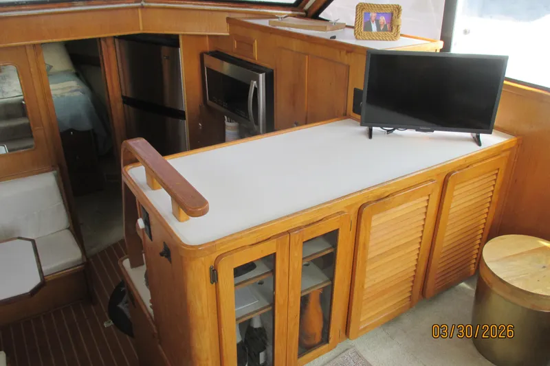 Slide: The Image of Interior of 1989 Chris Craft 427 yacht with kitchenette and TV setup. - 14