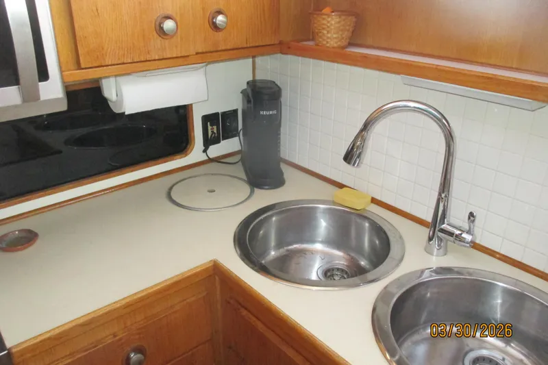 Slide: The Image of 1989 Chris Craft 427 kitchen with dual sinks, faucet, and wooden cabinetry. - 16
