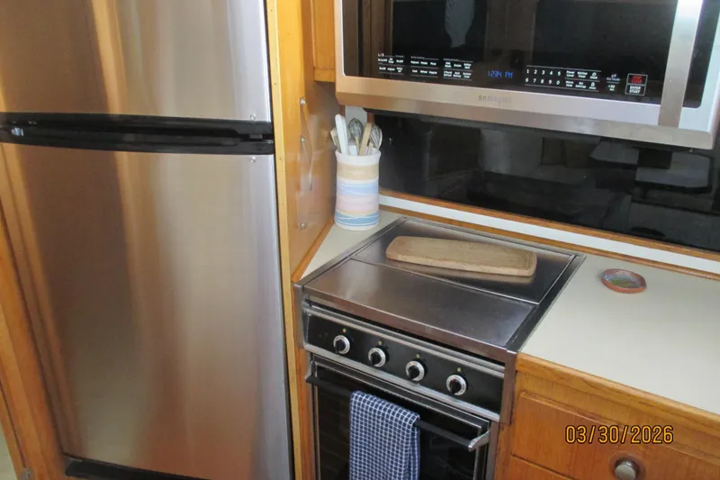 Slide: The Image of Compact kitchen area in a 1989 Chris Craft 427 boat with modern appliances. - 17