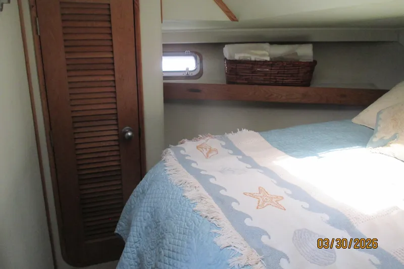 Slide: The Image of Cozy cabin bedroom in 1989 Chris Craft 427 yacht with nautical-themed bedding. - 19