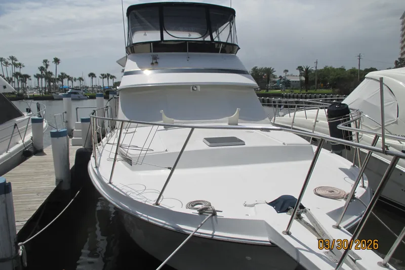 Slide: The Image of 1989 Chris Craft 427 yacht docked at marina, sunny day, palm trees in background. - 2