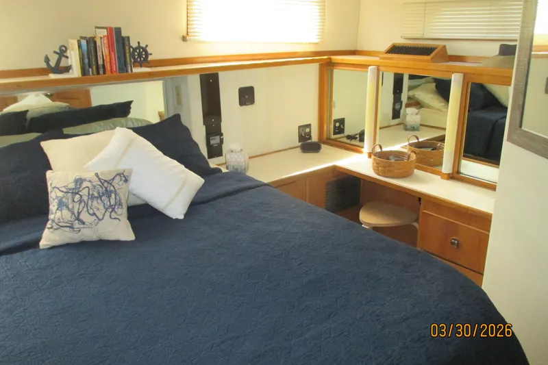 Slide: The Image of Cozy bedroom in 1989 Chris Craft 427 yacht with nautical decor and blue bedding. - 23