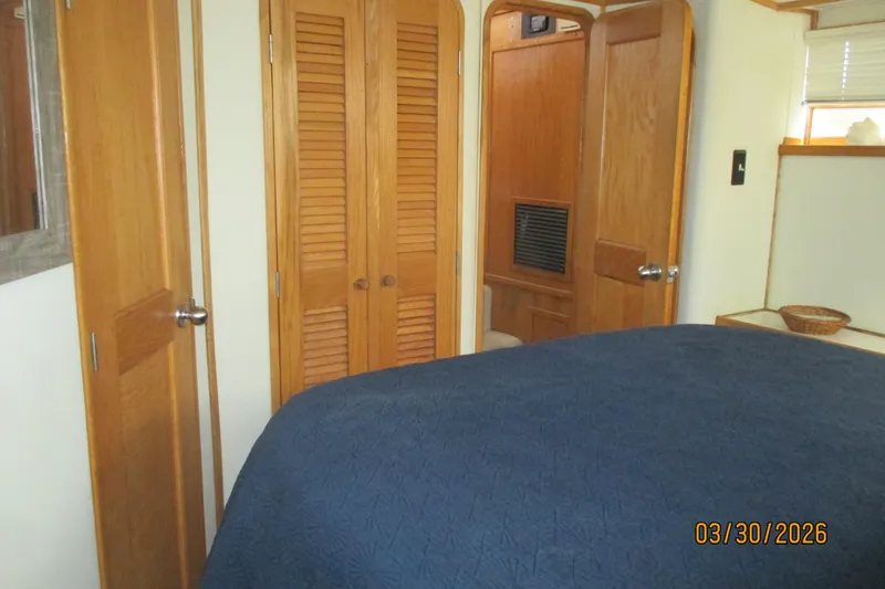 Slide: The Image of Interior of 1989 Chris Craft 427 yacht cabin with wooden doors and blue bedspread. - 25