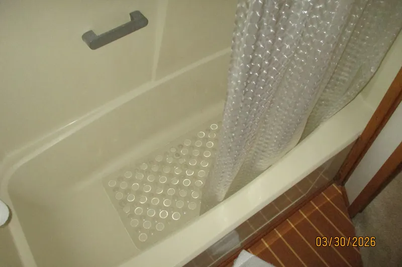 Slide: The Image of Bathtub with non-slip mat and shower curtain, dated March 30, 2026. - 27