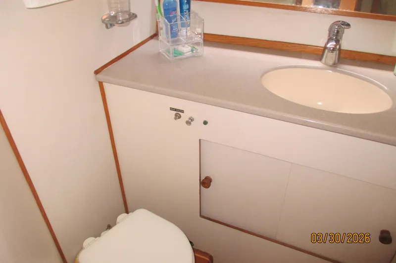 Slide: The Image of Bathroom interior of 1989 Chris Craft 427 yacht, featuring sink and toilet. - 28