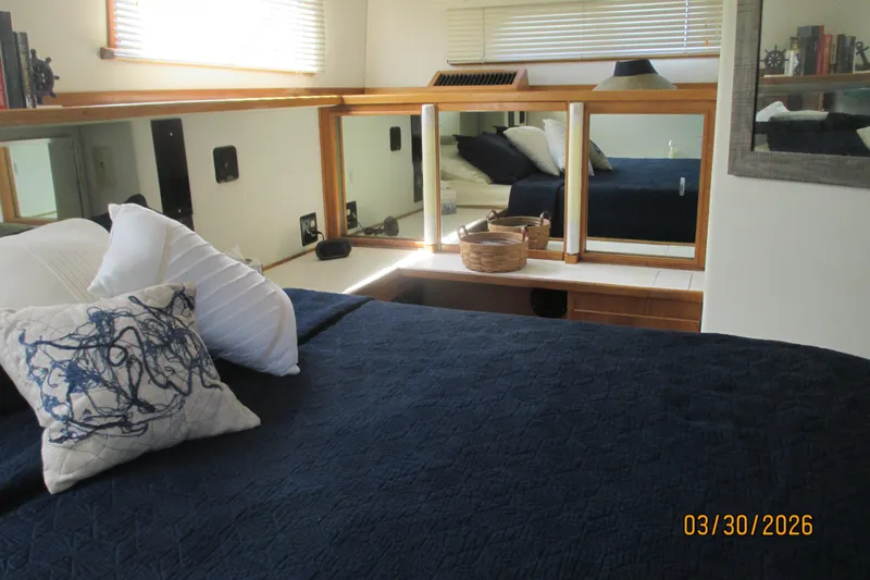 Slide: The Image of Cozy bedroom interior on 1989 Chris Craft 427 yacht with navy bedding and decorative pillows. - 29