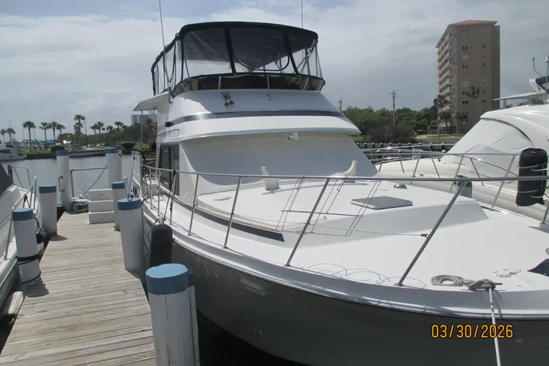 Slide: The Image of 1989 Chris Craft 427 yacht docked at marina, featuring sleek design and spacious deck. - 3