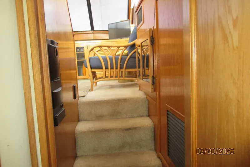 Slide: The Image of Interior view of 1989 Chris Craft 427 yacht with wooden paneling and carpeted stairs. - 31