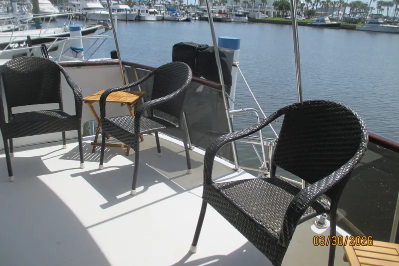 Slide: The Image of Deck of 1989 Chris Craft 427 yacht with wicker chairs and marina view. - 36