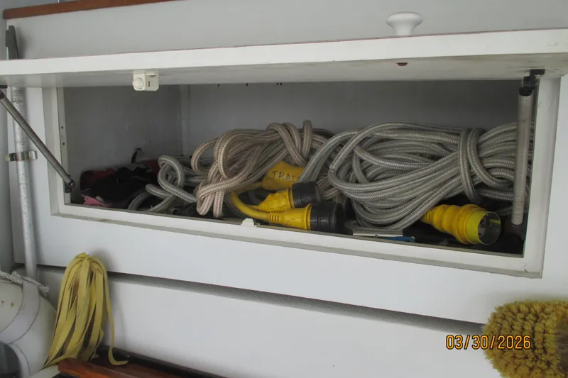 Slide: The Image of Storage compartment on a 1989 Chris Craft 427 boat with ropes and cables. - 38
