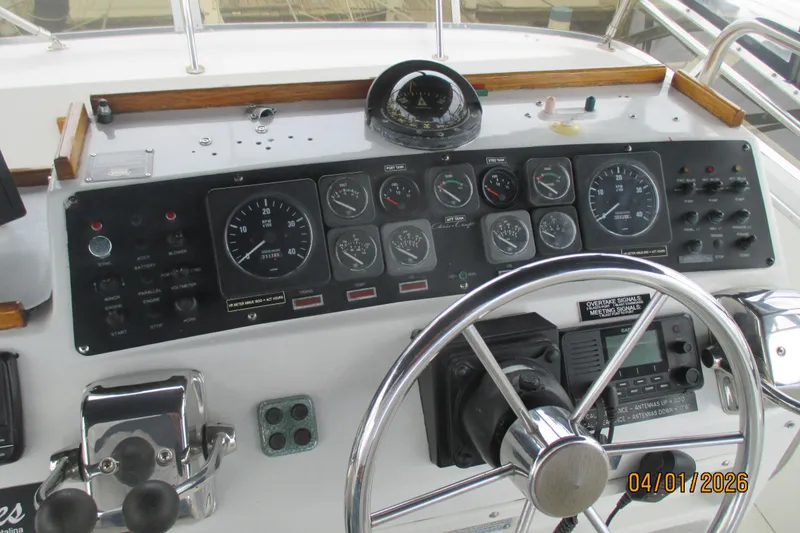 Slide: The Image of Control panel of a 1989 Chris Craft 427 Catalina boat with steering wheel and gauges. - 43