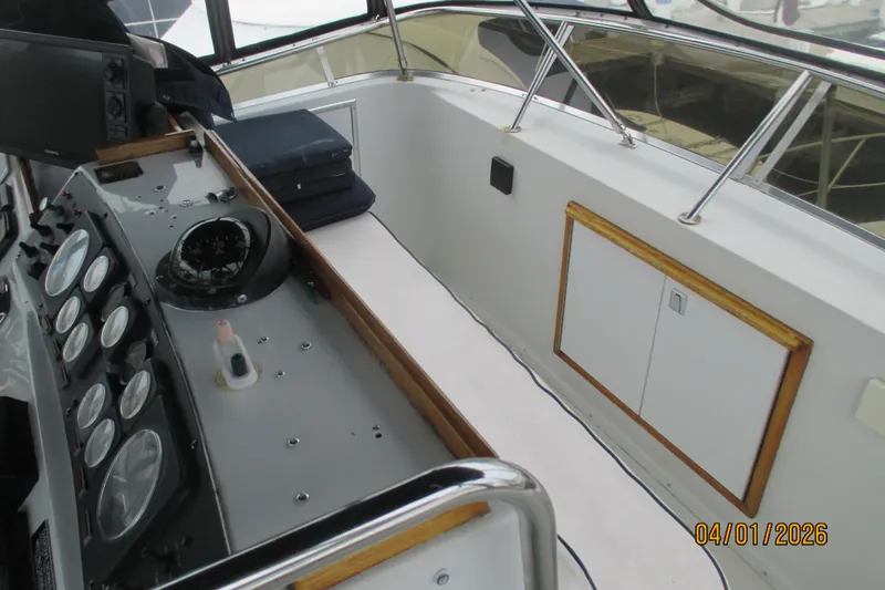 Slide: The Image of 1989 Chris Craft 427 Catalina helm with gauges and compass, showcasing classic boat design. - 45