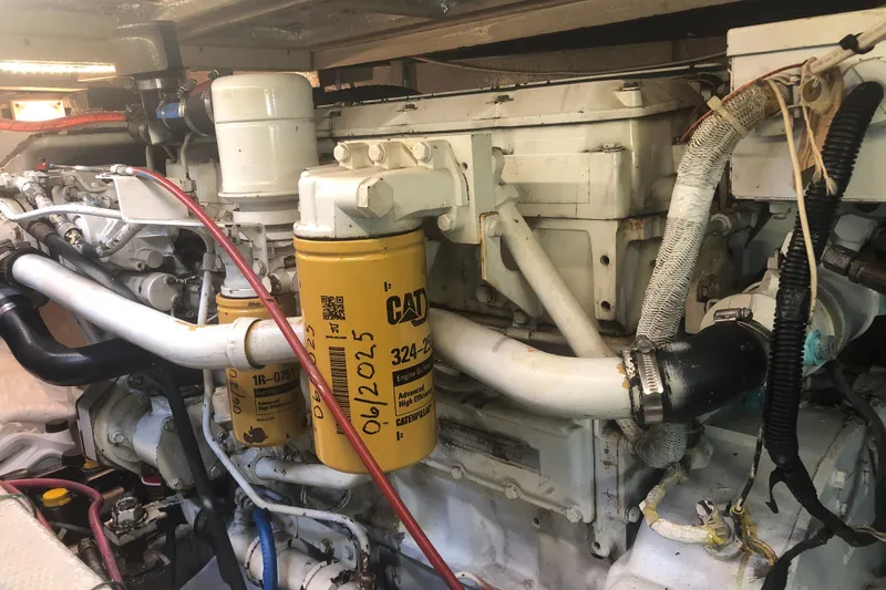 Slide: The Image of Engine compartment of a 1989 Chris Craft 427 boat, featuring CAT filters and hoses. - 48