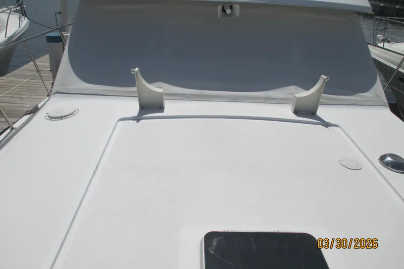 Slide: The Image of 1989 Chris Craft 427 boat deck with white surface and docked surroundings. - 7
