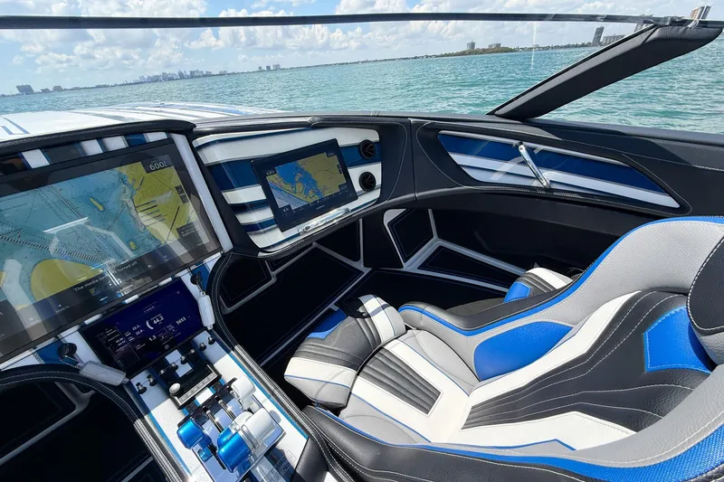 Slide: The Image of 2024 MTI 440X boat cockpit with advanced navigation displays and luxurious seating on open water. - 9