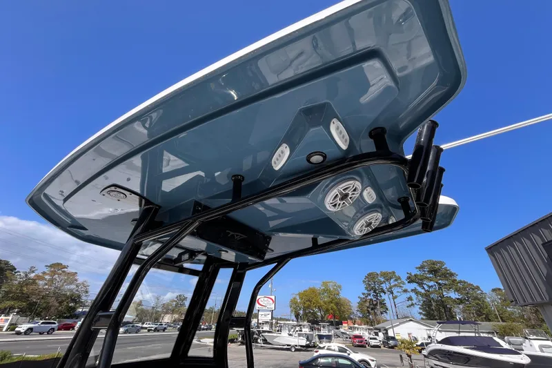 Slide: The Image of 2026 Tidewater 2500 Carolina Bay boat with T-top and speakers, under clear blue sky. - 13