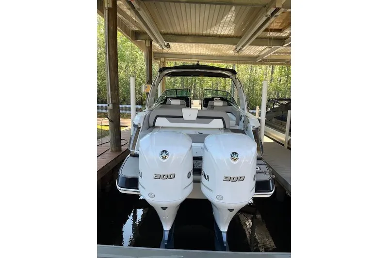Slide: The Image of 2020 Four Winns H290 OB boat with dual Yamaha 300 outboard engines in a covered dock. - 8