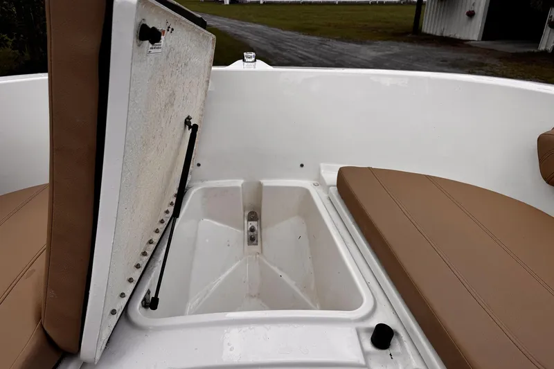 Slide: The Image of 2023 Bayliner Trophy T20CC boat with open storage compartment and tan seating. - 15
