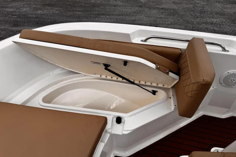 Slide: The Image of 2023 Bayliner Trophy T20CC boat with open storage compartment and cushioned seating. - 16