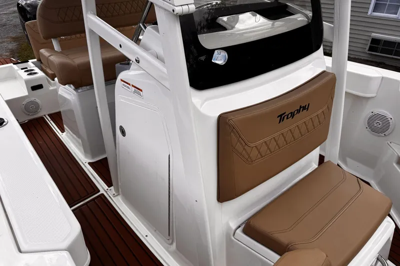 Slide: The Image of 2023 Bayliner Trophy T20CC boat interior with brown seating and white console. - 18