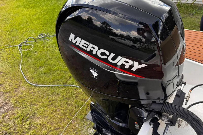 Slide: The Image of Mercury outboard engine on 2023 Bayliner Trophy T20CC boat, parked on grass. - 26