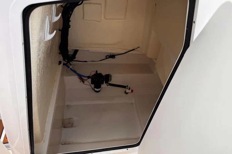 Slide: The Image of 2023 Bayliner Trophy T20CC storage compartment interior with wiring and pump. - 31