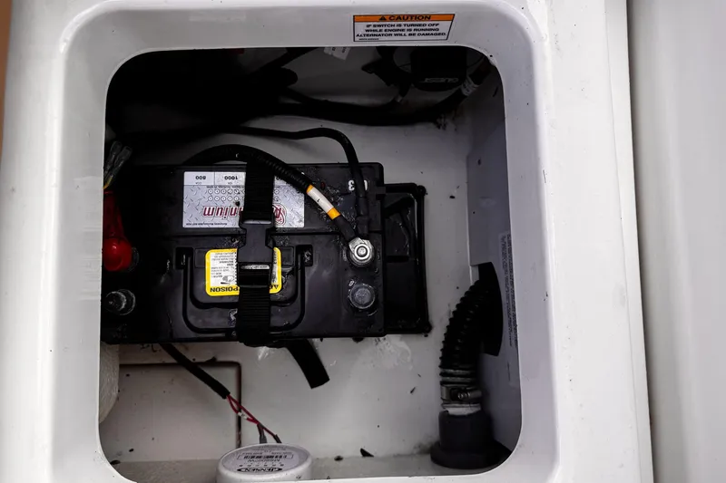 Slide: The Image of 2023 Bayliner Trophy T20CC boat battery compartment with secured battery. - 33