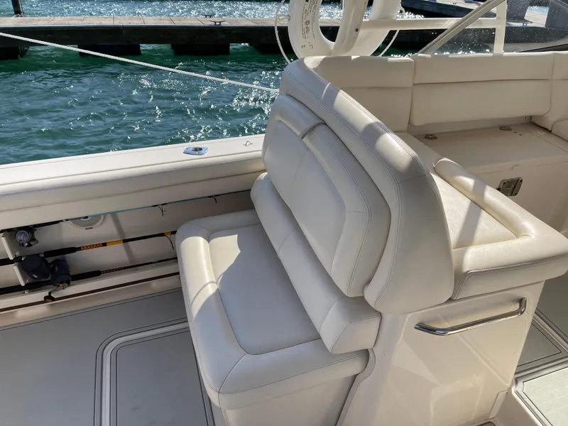 Slide: The Image of 2016 Grady-White Freedom 335 boat interior with white seating by the water. - 16